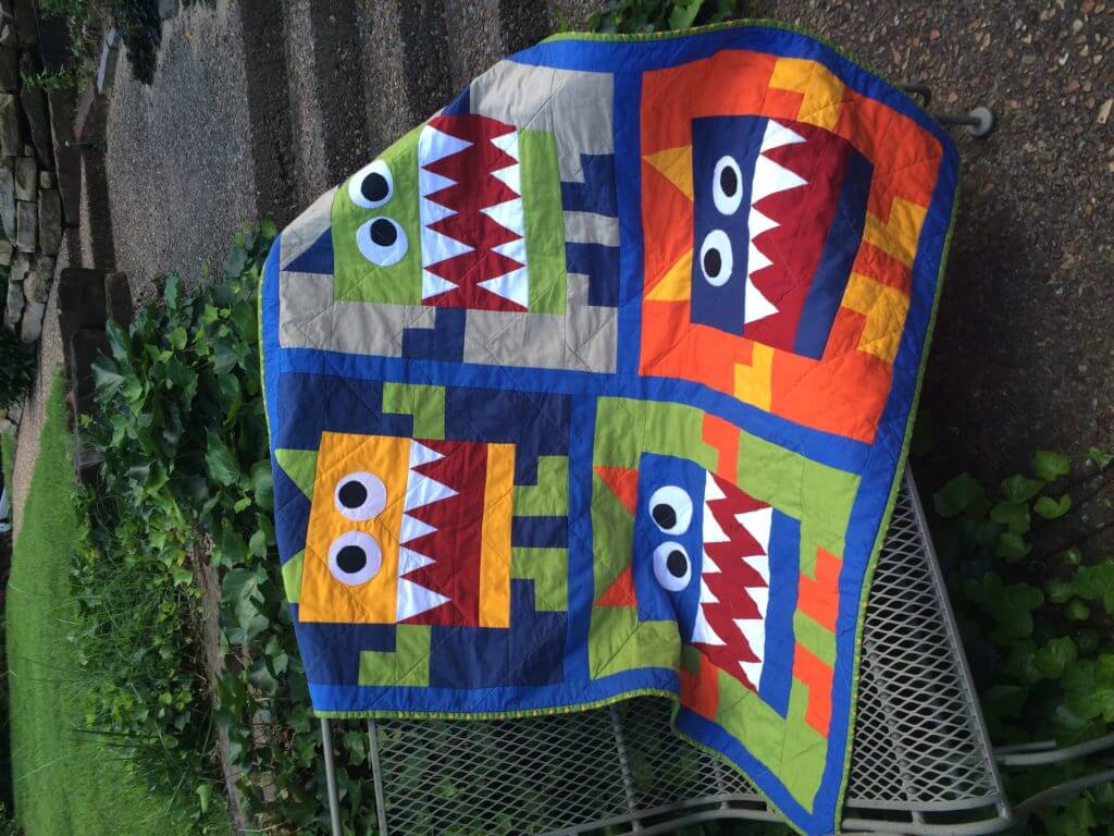 colorful quilt with monsters pieced in design