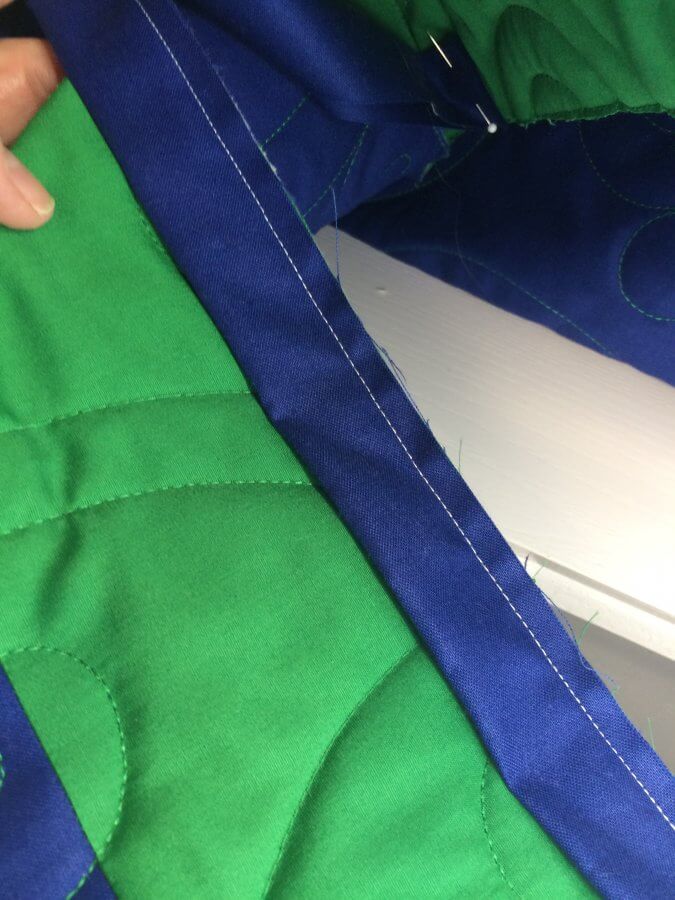 photo of green quilt with blue binding attached