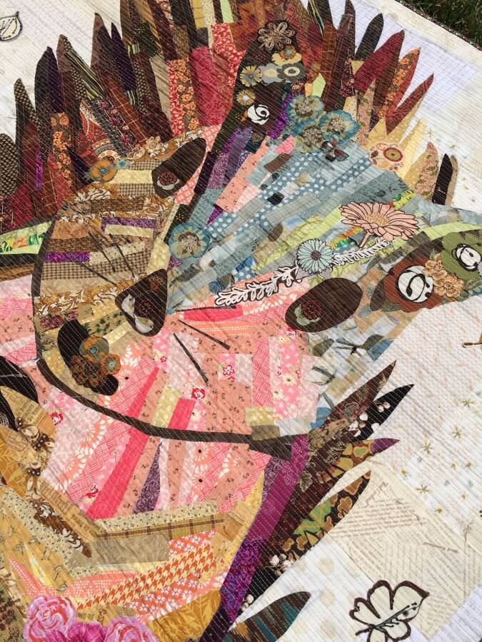 a close up photo of a collage quilt depicting a squirrel