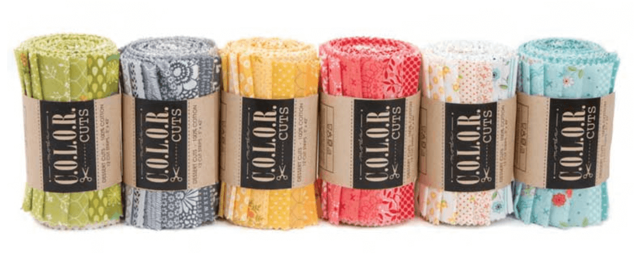 Photo of precut bundles of fabric by Moda sorted by color