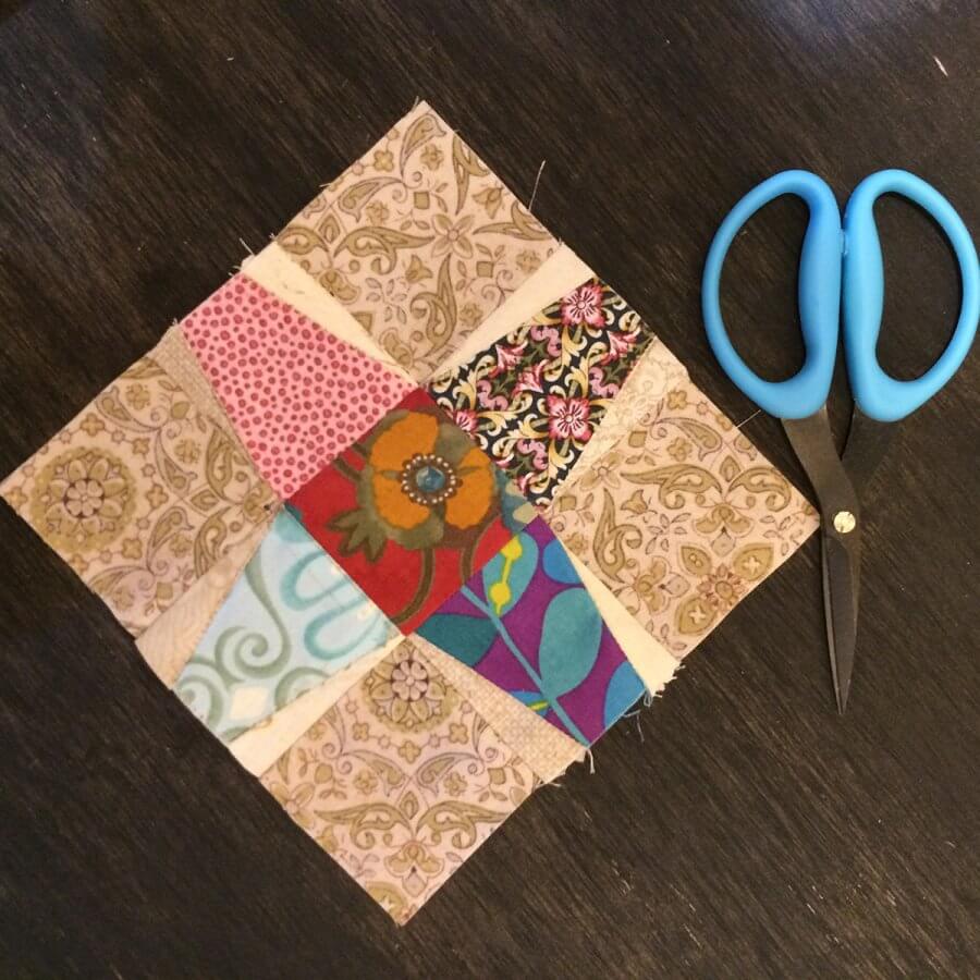 Photo of a Tumble Jack Quilt Block beside a pair of scissors