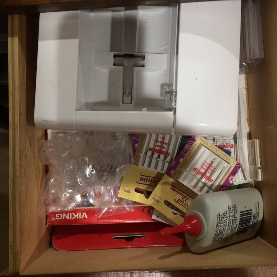 Photo of a drawer holding sewing machine needles and machine oil