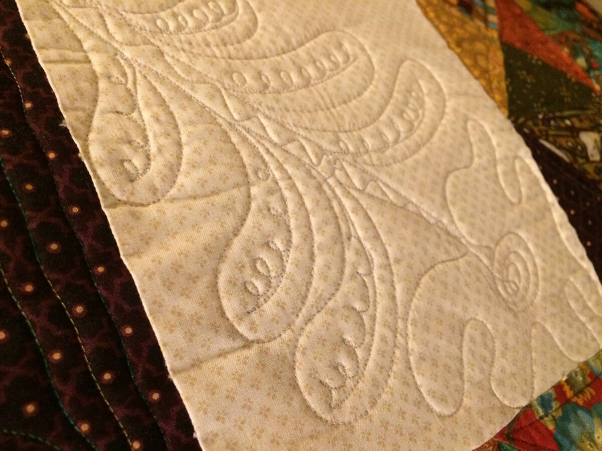Photo showing custom quilting design stitched onto a quilt