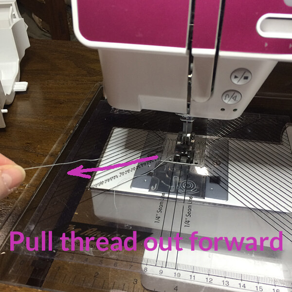 photo showing proper way to pull thread out of a sewing machine