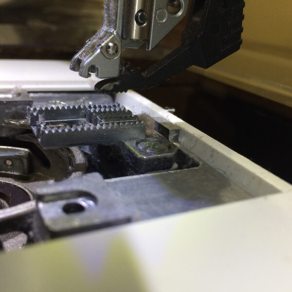 photo showing link accumulation in the feed dogs of a sewing machine