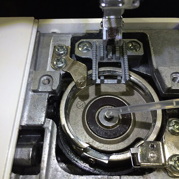 photo that demonstrates where to drop oil in hook device of sewing machine