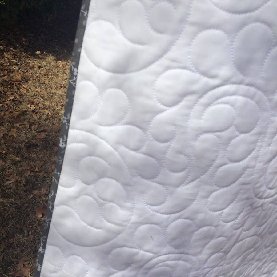 Closeup showing gray binding on a white quilt