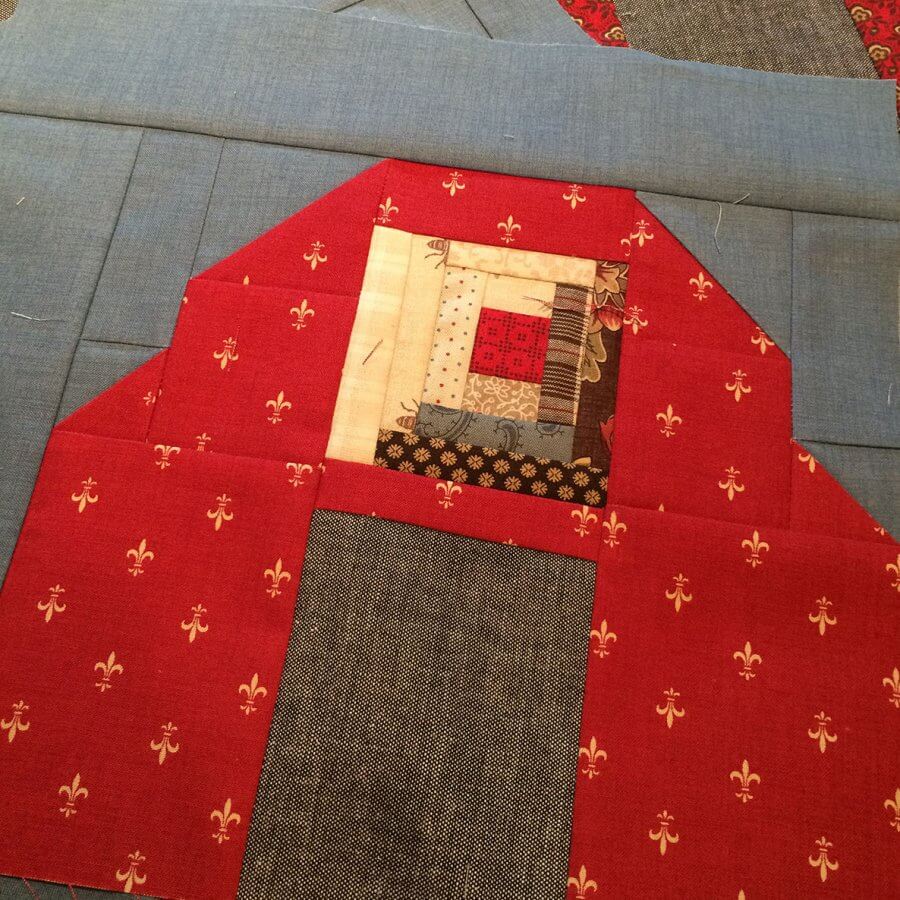 photo of log cabin patchwork set in a barn quilt block 