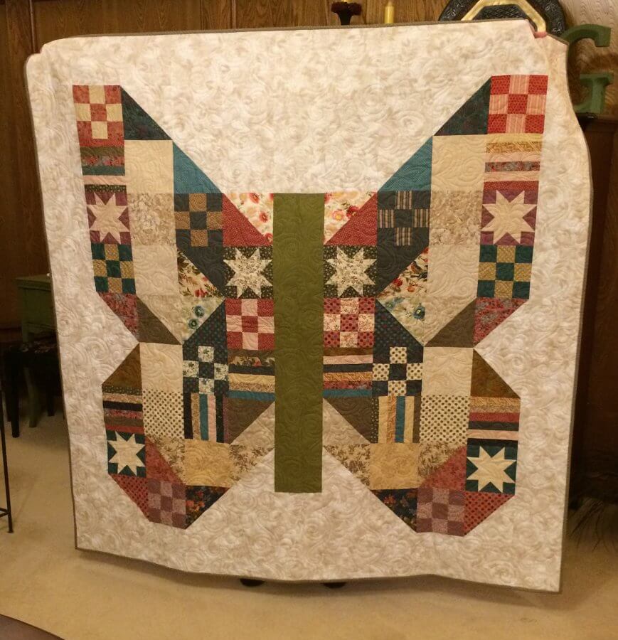 Picture of a quilt with blocks in shape of a butterfly