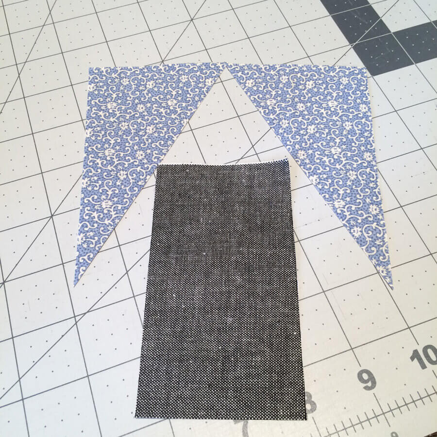 One rectangular and two triangular pieces of fabric for making steeple unit for house of prayer church quilt block