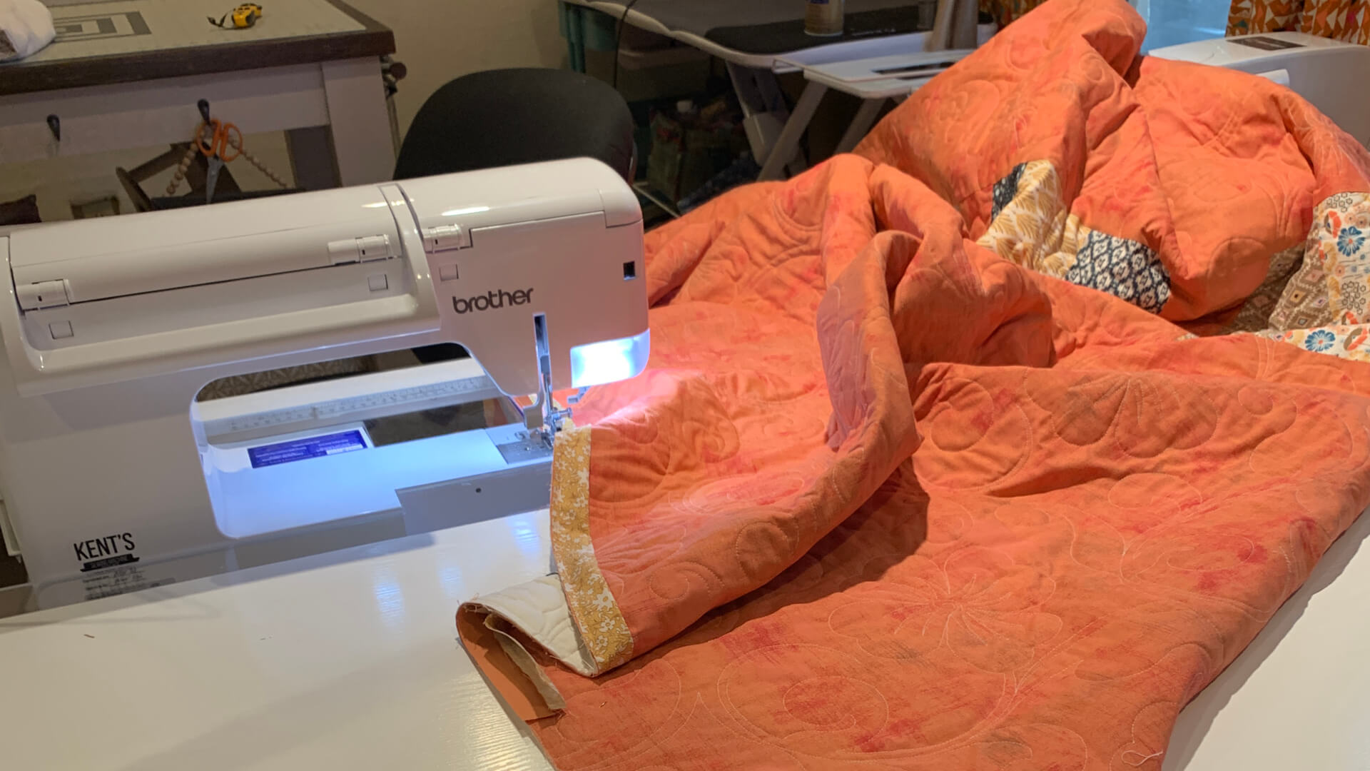 A photo of a sewing machine with a quilt loaded on the table ready for binding