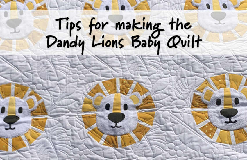 Photo of the Dandy Lions Baby Quilt, which features nine lion faces appliquéd on a white background